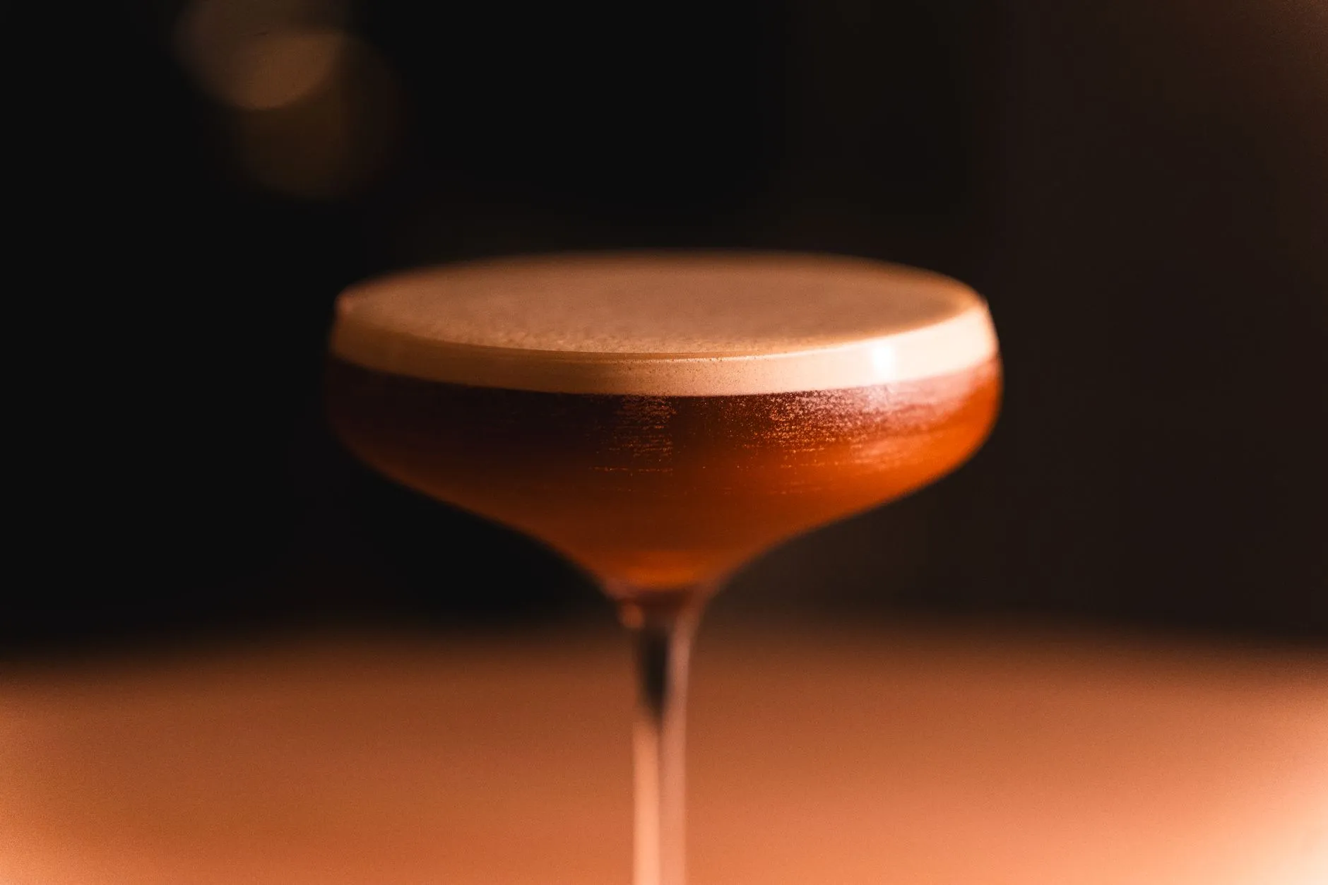 Ein geschichteter Cocktail im Coupe-Glas in einer Bar