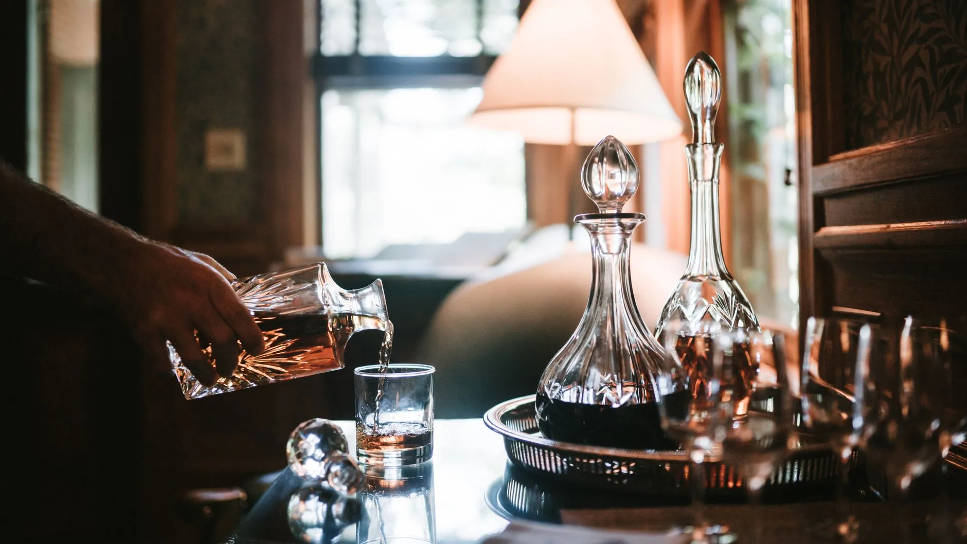 Whisky wird aus einer Karaffe in ein Glas gegossen