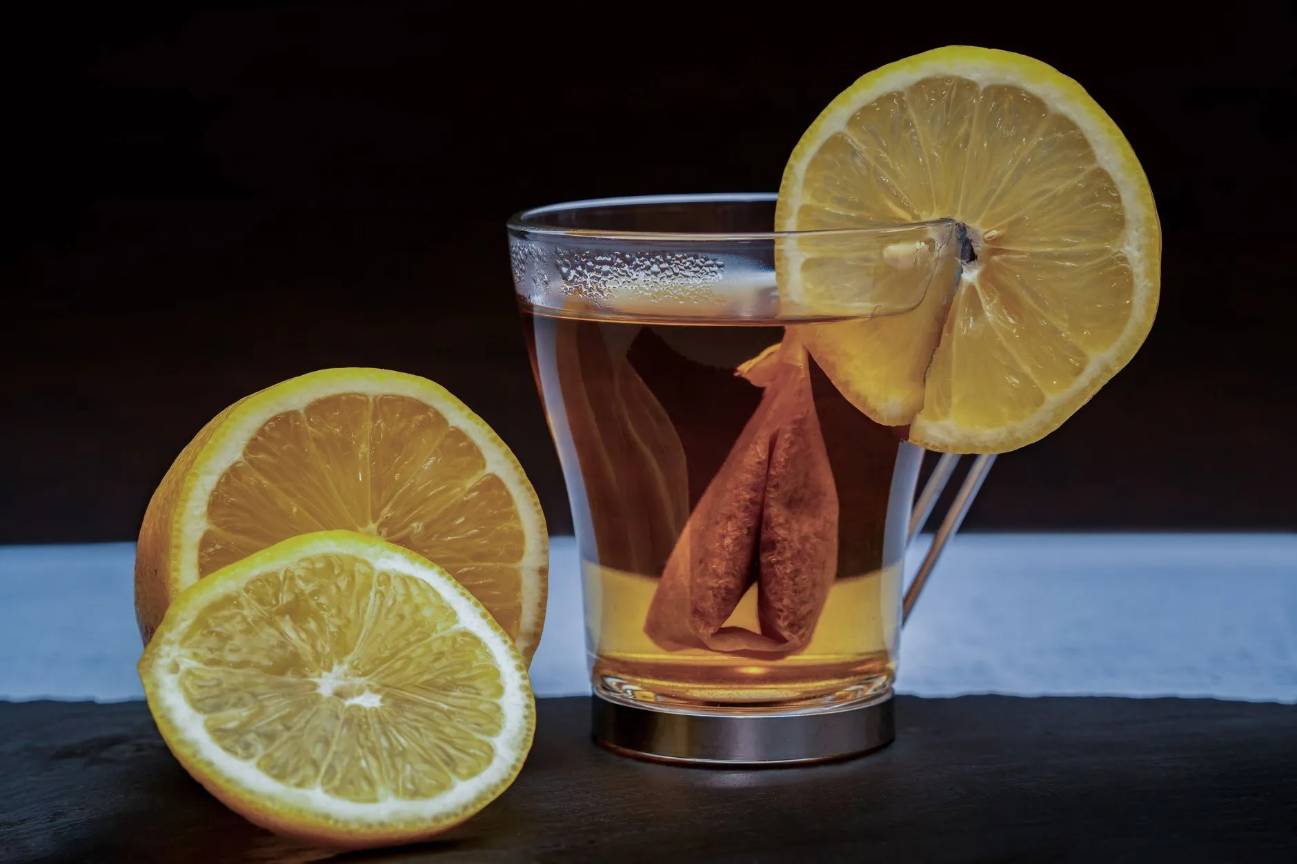 Ein heißer Zitronen-Ingwer-Drink im Glas mit Zitronenscheiben
