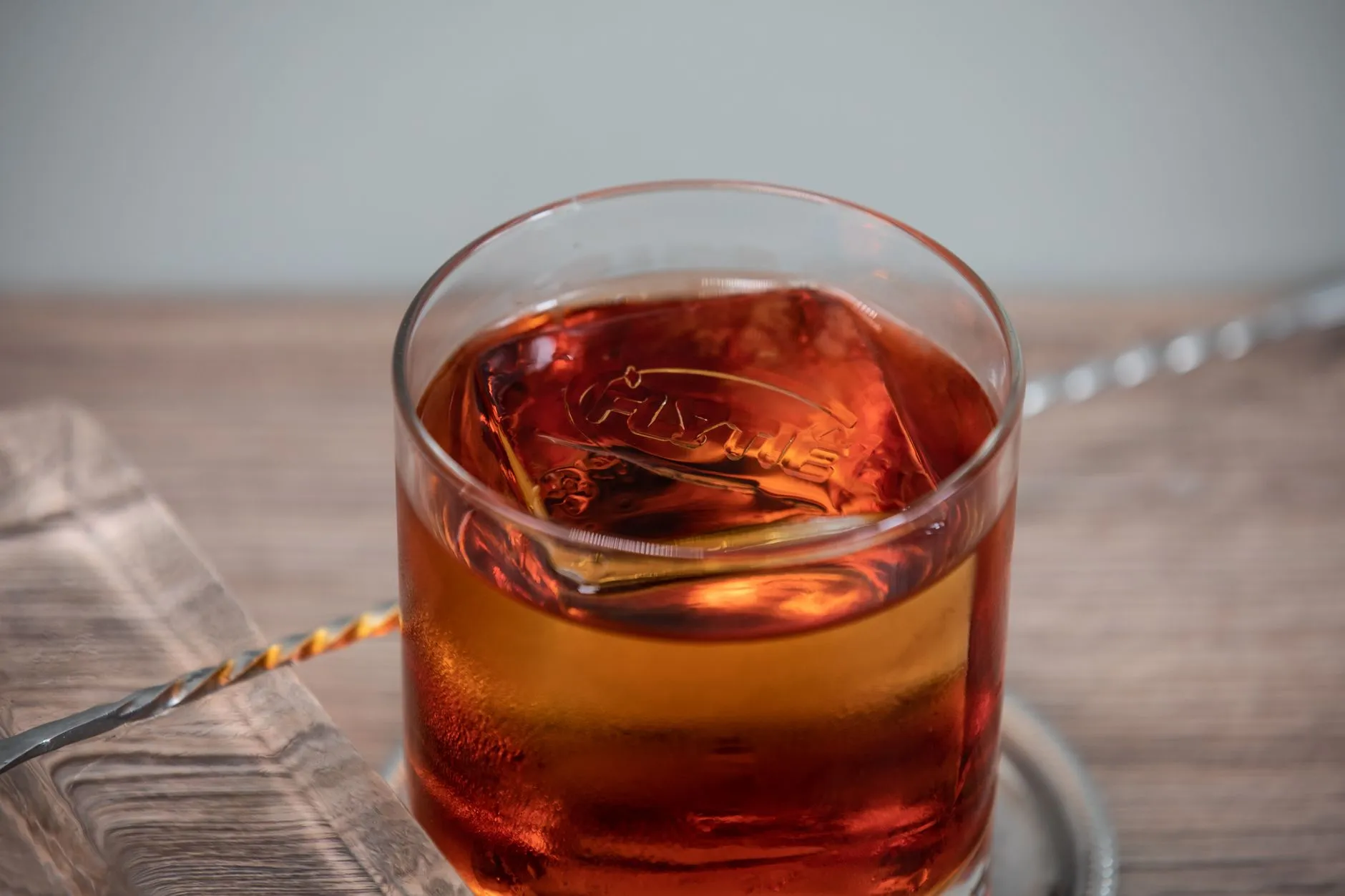 Ein Glas Whisky mit Eis auf einer Holzfläche