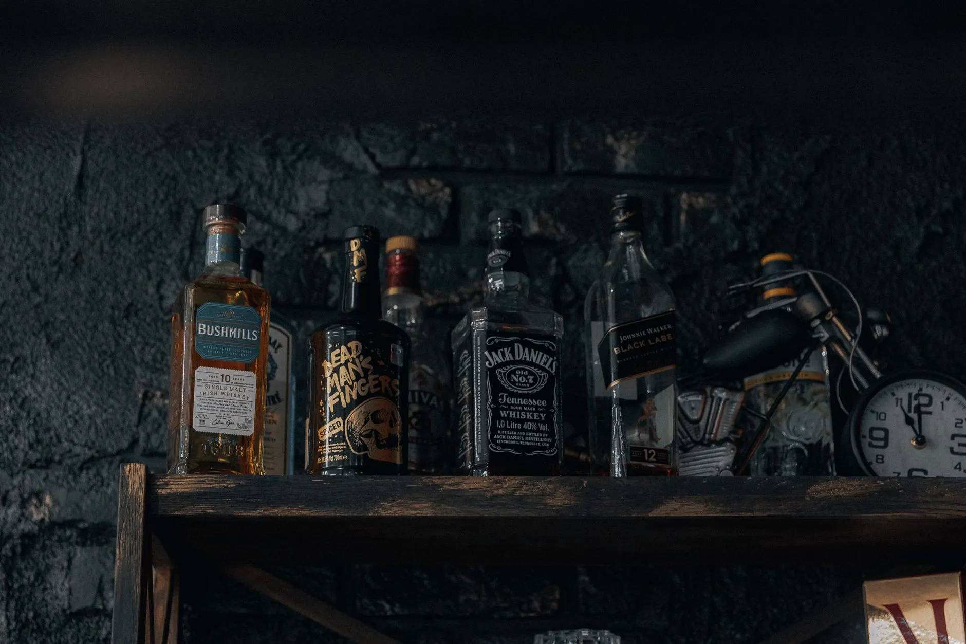 Whiskyflaschen stehen in einem dunklen Holzregal