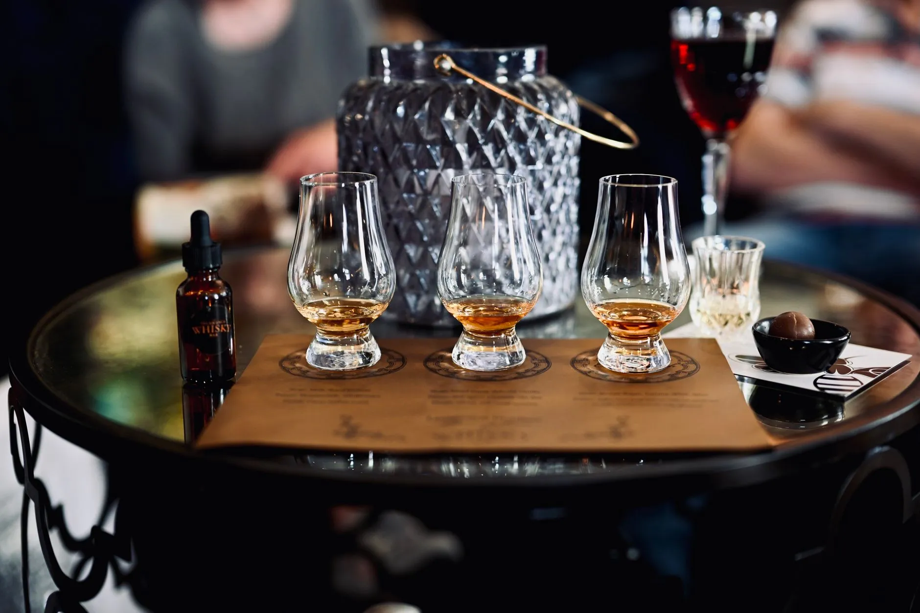 Whiskygläser auf einem Holzbrett bei einer Verkostung
