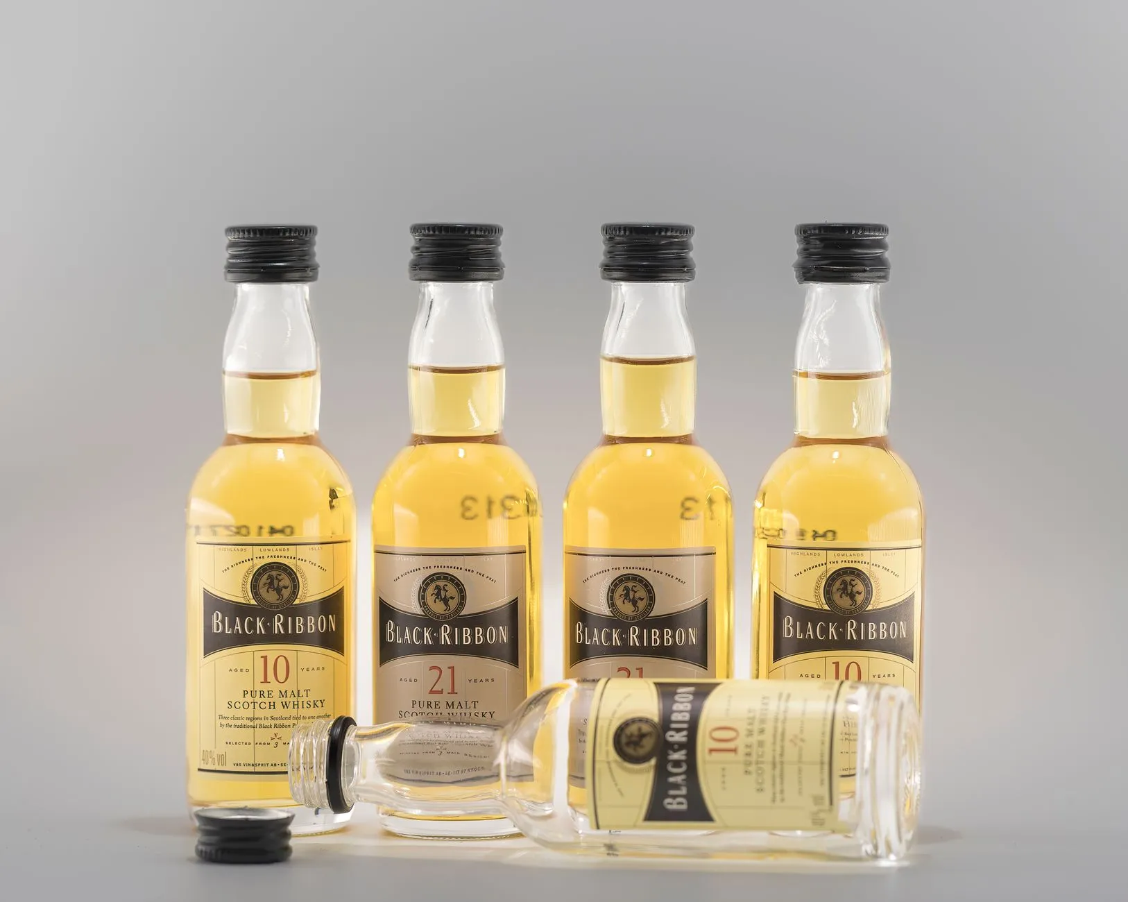 Mehrere kleine Flaschen mit bernsteinfarbenem Whisky