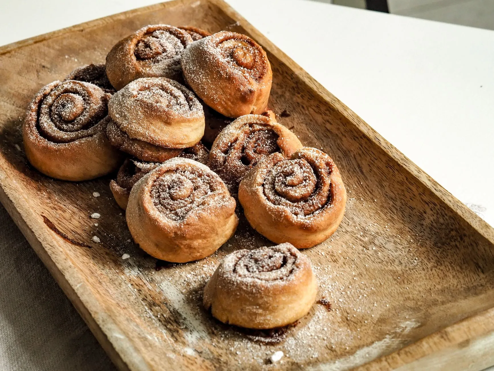 Frisch gebackene Zimtschnecken auf einem Holztablett